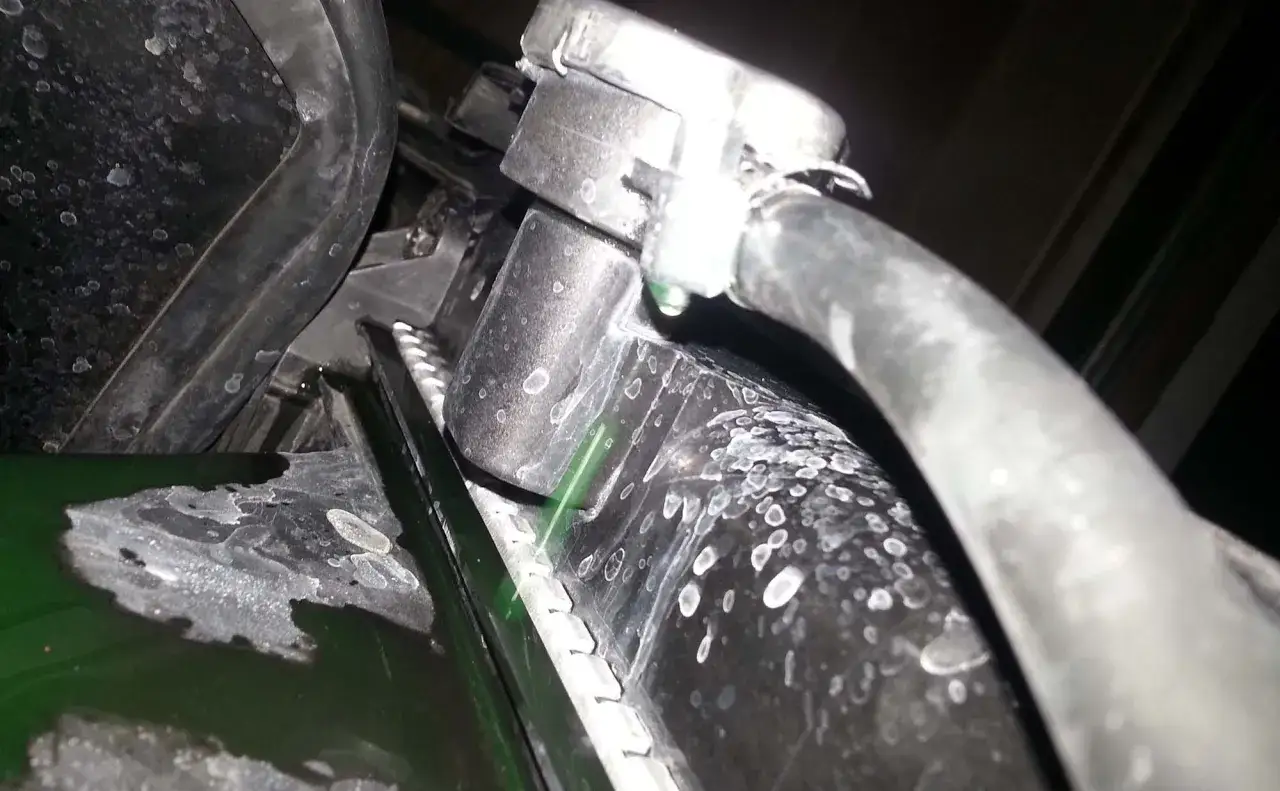 Fuite de liquide de refroidissement verte sur le radiateur d'une voiture. La réparation du radiateur auto est nécessaire.
