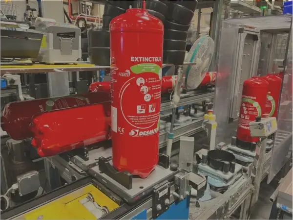 Extincteurs rouges en production, conformes à la réglementation extincteur poids lourds. Ils sont prêts pour la sécurité des véhicules.