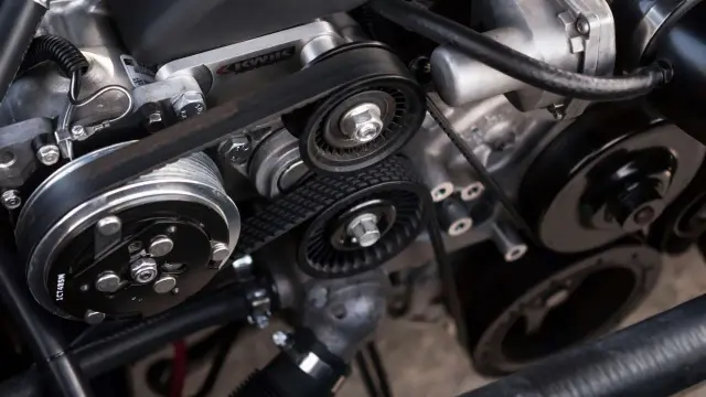 Détail d'un moteur avec courroies tendues, prêt à rugir. On entend presque le claquement moteur.